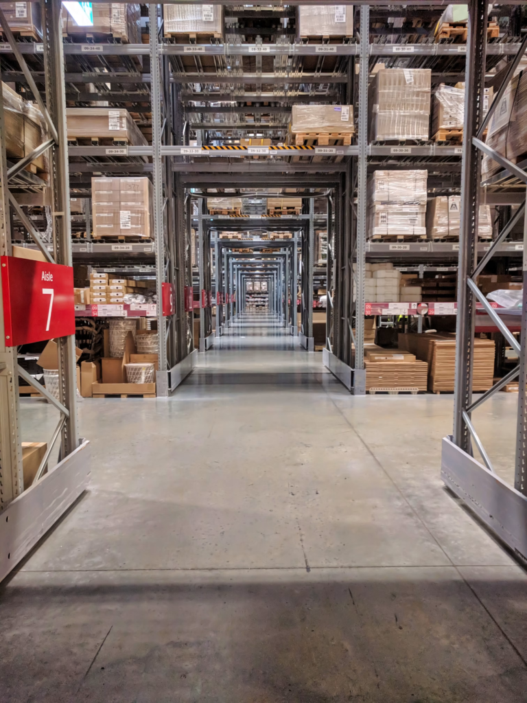 Warehouse aisle lined with tall shelving stocked with boxes